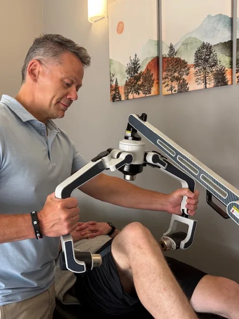 Chiropractor Calgary AB John Scott Laser Patient copy Chiropractor John Scott with a laser therapy patient.