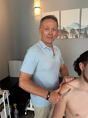 Chiropractor Calgary AB John Scott Using Graston Technique On Patient