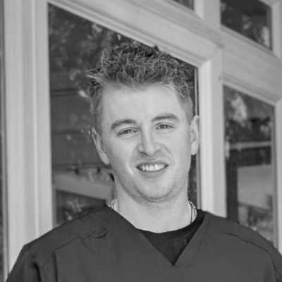 Bryan Polmear smiling. The photo is black and white.